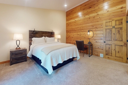 Hilltop bedroom with pine walls and white bedding