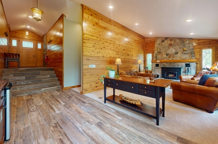 Living space looking toward entry way with couch, chairs, and fireplace