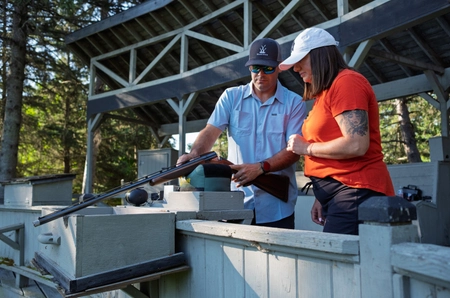 A woman getting instruction on how to shoot a gun