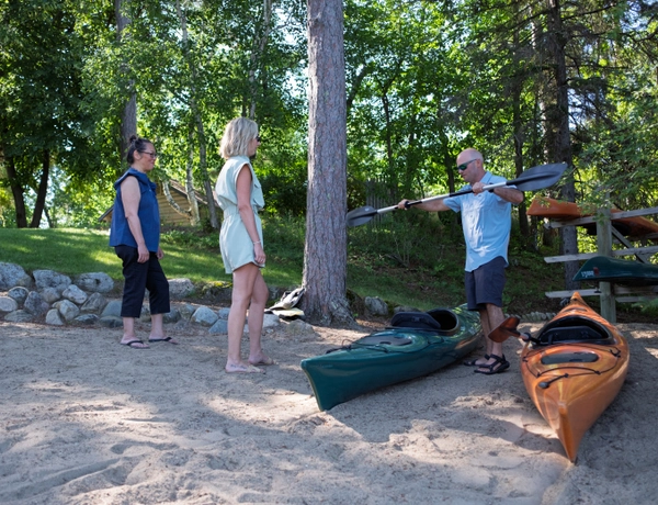Two people being taught how to use a paddle for kayaking