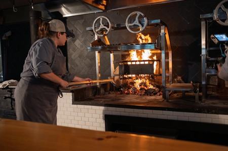 Chef cooking on open flame stove