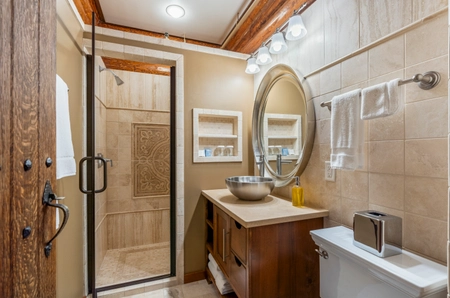 Bathroom in the main lodge with a walk-in shower and round mirror