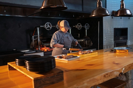 Chef cutting steak on a cutting board in the kitchen